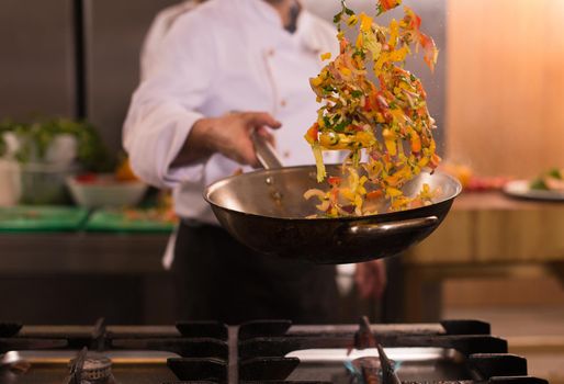 chef flipping vegetables in wok