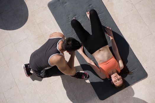 young handsome woman with personal trainer doing morning yoga exercises in front of her luxury home villa top view