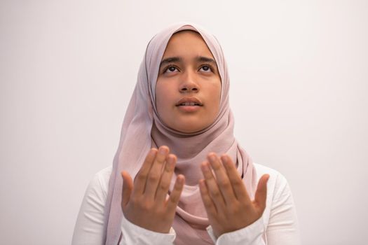 Arab female Muslim in traditional hijab clothes praying namaz dua open hands to Allah