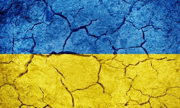 Ukraine flag on dry earth ground texture background