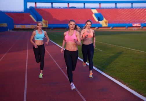 athlete woman group  running on athletics race track