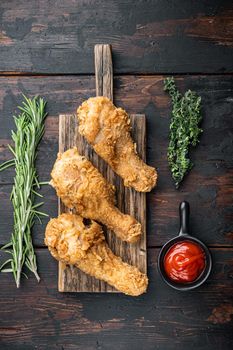 Crispy fried chicken on dark wooden background, top view