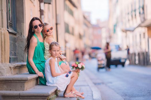 Mother with little cute daughters eating ice-cream outdoor