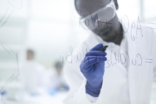 scientist writing chemical formula on a glass Board