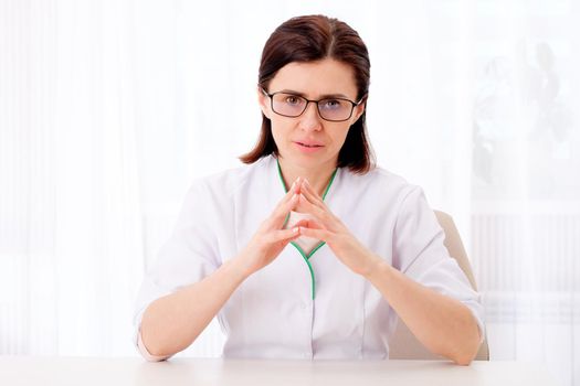Female pediatrician sitting at the table