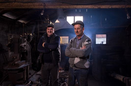 portrait of two generations confident blacksmith