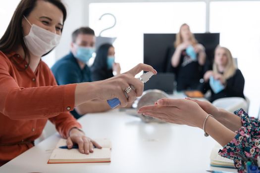new normal businesspeople on meeting using antibacterial hand sanitizer