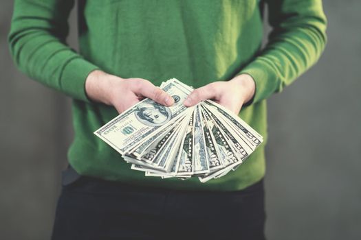 business man displaying a spread of american dollar cash money