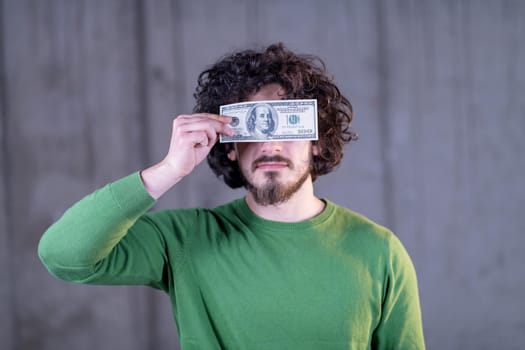 business man holding american dollar banknote over the eyes