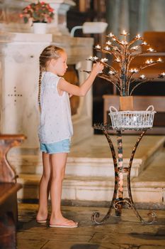 Little girl in church with candles indoor