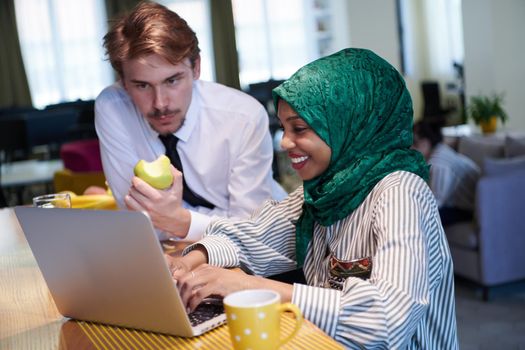 international multicultural business team working together on laptop