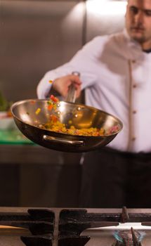 chef flipping vegetables in wok