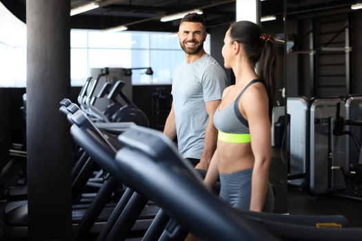 Attractive people on the treadmill at sport gym.