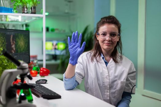 Biochemist woman greeting remote scientist discussing microbiology experiment