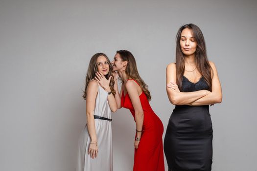 two women gossips about their third friend