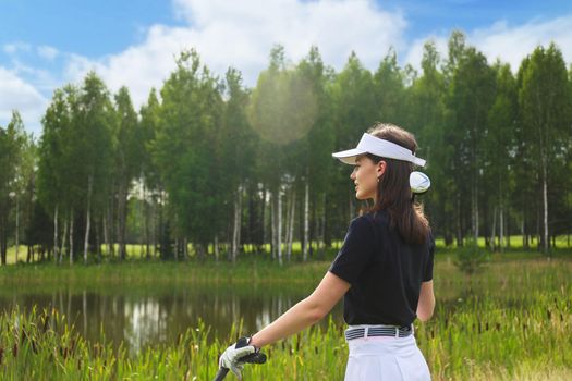Young woman on golf course, back view