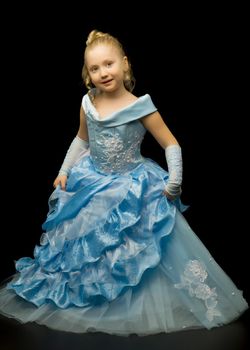 A little girl in a long, elegant dress of a princess on a black