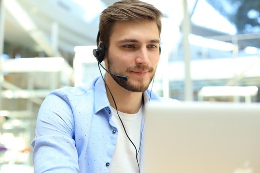 Happy young male customer support executive working in office.