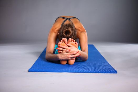 Portrait of sport girl doing yoga stretching exercise .