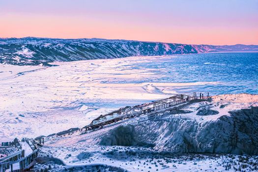 Winter wonderland and Christmas fantasy landscape. Frozen sea coast and mountains covered with snow as holiday background