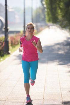 sporty woman running  on sidewalk