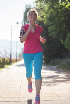sporty woman running  on sidewalk