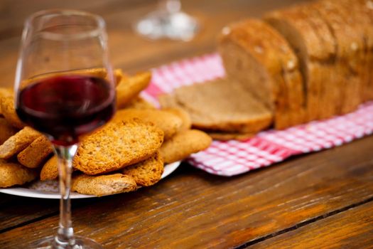 glass of red wine and toasted bread on wooden table