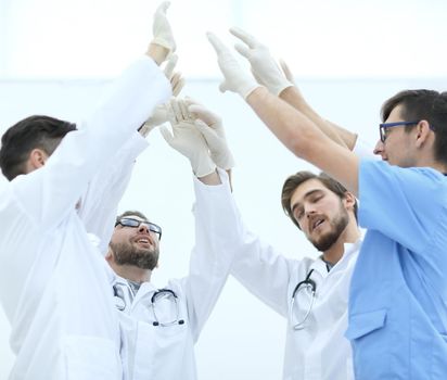 surgical team raising their hand