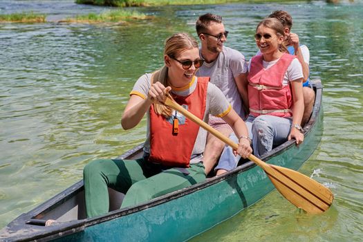 Group adventurous explorer friends are canoeing in a wild river