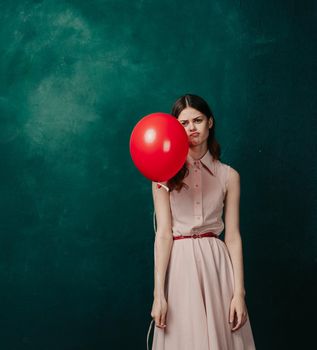 woman with red balloon celebration birthday green background. High quality photo