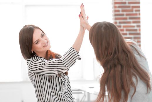two young co-workers giving each other a high five