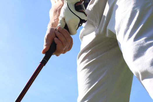 Golfer wearing a golf holding a putter.