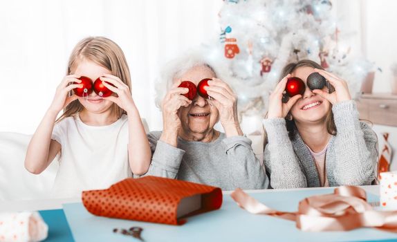 Granddaughters holding balls like eyes with grandma