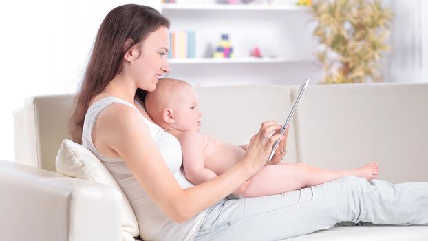mother and baby are looking to play and read tablet computer
