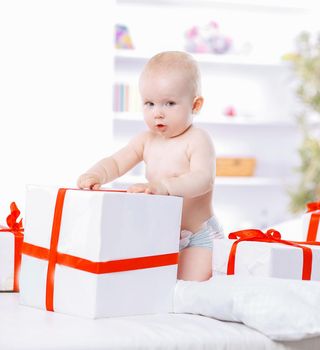 pretty baby plays with gift boxes. photo with copy space