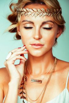 young blond woman dressed like ancient greek godess, gold jewelry close up isolated, beautiful girl hands manicured red nails