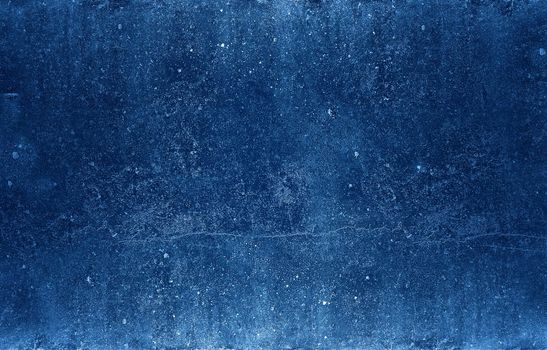 Grunge uneven dark blue stone texture background with cracks and stains