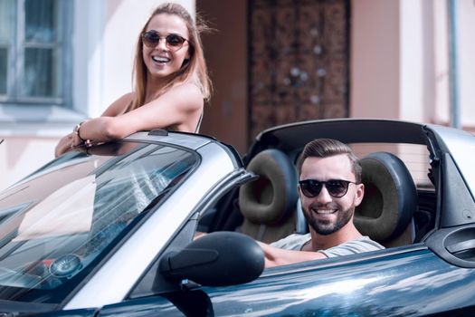 young couple in convertible car.
