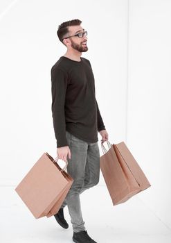 Portrait of a man with a full paper bag on a gray