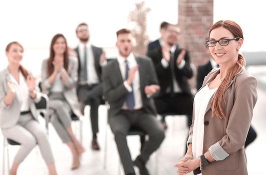 business woman on blurred background of listeners in conference room
