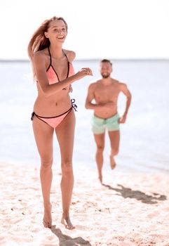 Happy fun beach vacations couple walking together laughing havin