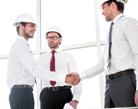 Two architects shaking hands after a meeting in office