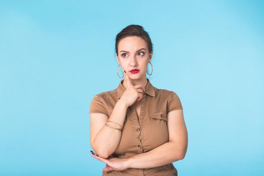 Concerned young woman on blue background