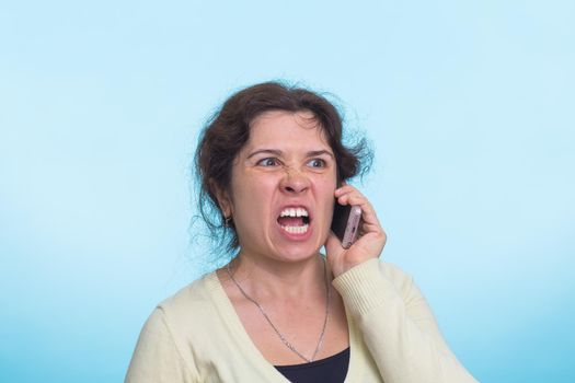 Angry aggressive woman screams on cell phone