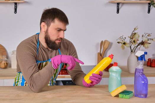 Young man wanted to help his wife in housecleaning, but he doesn't know what to do with all of detergents