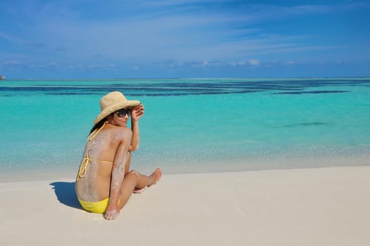 happy young pretty asian woman resting on sand at beach