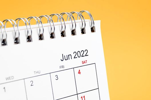 June 2022 desk calendar on yellow background.