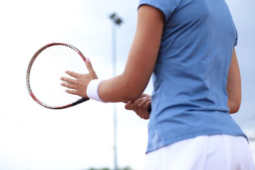 Sportswoman with racquet at the tennis court. Healthy lifestyle.