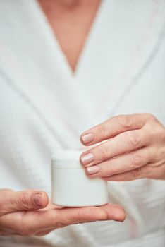 Cream bottle in manicured woman hands