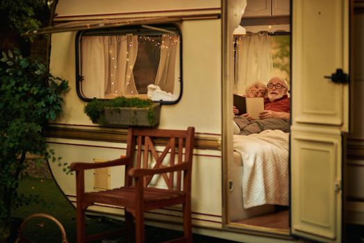 Smiling elderly spouses resting in their camper van